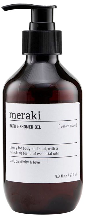 En mörk flaska med pump, märkt 'meraki bath & shower oil' med vit text och beskrivning.
