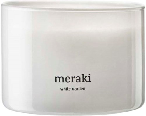 Een witte kaarsenpot met zwarte tekst die "meraki" en "white garden" zegt.