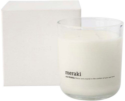 Ett vitt ljus i glas med en enkel box i närheten. Ljuset har ordet 'meraki' på sig.