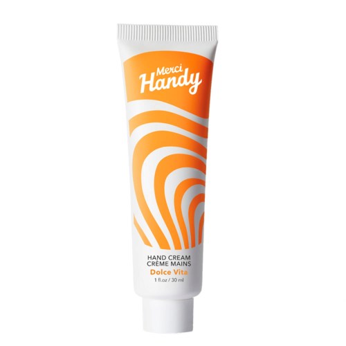 En vit tub med handkräm med orange swirl-design och text, inklusive märkesnamnet 'Merci Handy' och produktuppgifter.