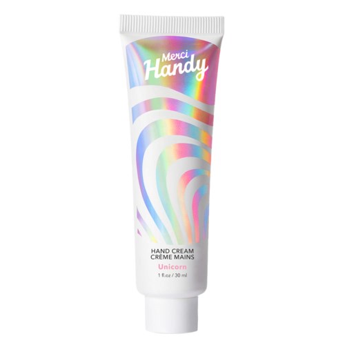 En tub med handkräm med färgglada regnbågssvansar och texten 'Merci Handy' ovanpå.