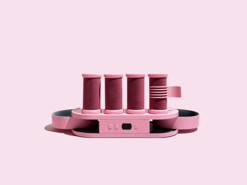 Een roze apparaat met vier verticale rollen en een bedieningspaneel, bedoeld voor verzorging of schoonheid.