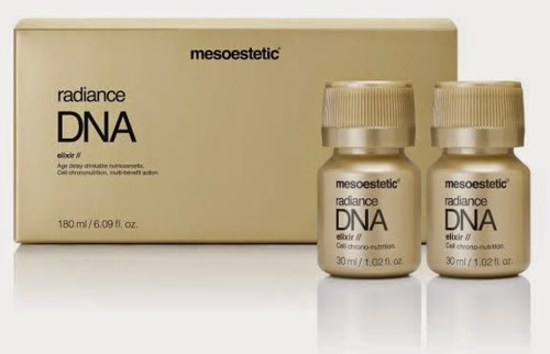 Två små flaskor och en stor låda märkt 'mesoestetic radiance DNA', troligen hudvårdsprodukter, i beige och guld.
