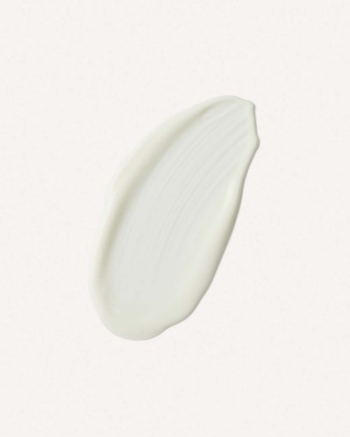 A dollop of white cream or lotion on a plain background.