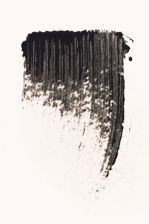 A black brush stroke with thick paint at the top fading downward into thinner spray marks.
