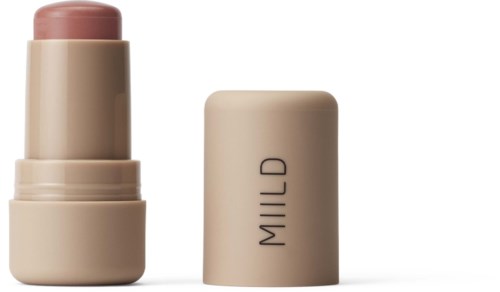 En beige kosmetikflaske med en lys rosa læbebalsam, og teksten "MILD" på låget.
