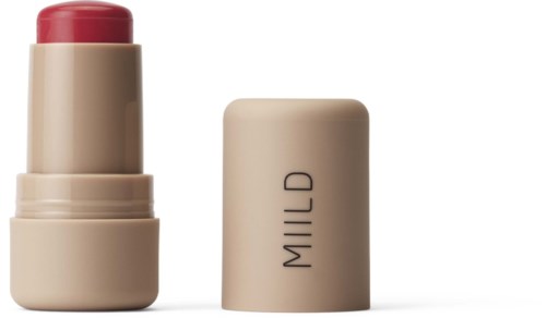 En læbestift i beige etui, med låget ved siden af, der viser pink-til-rød farve.