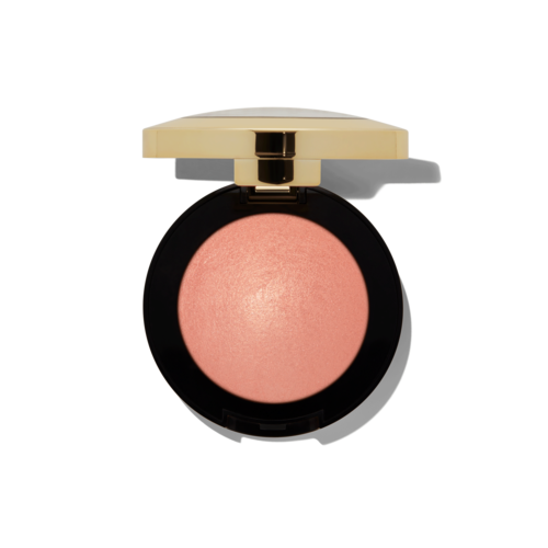 A round blush in a black container with a gold lid. The blush is peach-colored and shiny.