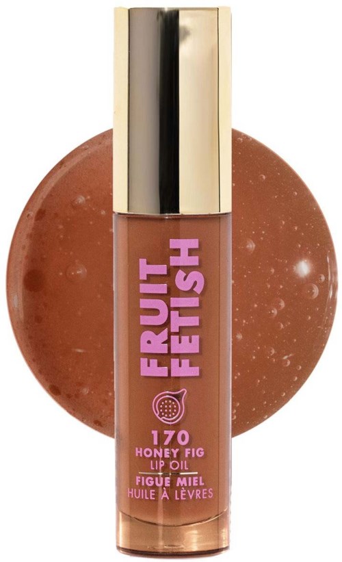 Lip oil tube labeled 'Fruit Fetish' in purple, with a honey fig flavor, placed in front of a brown circular background.