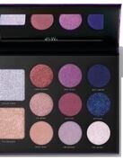 Een make-uppalette met verschillende gekleurde oogschaduws en blushes in een zwart komplete.
