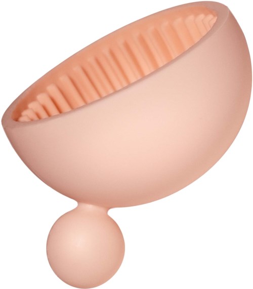 En ljusrosa lermaskapplikator med texturerad insida och en rund handtag.