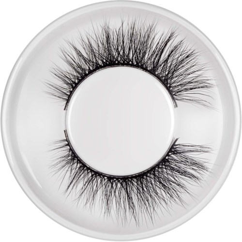 Falska ögonfransar på en vit tallrik i en cirkulär form. Långa, tjocka och spretiga. Används för ögonmakeup.