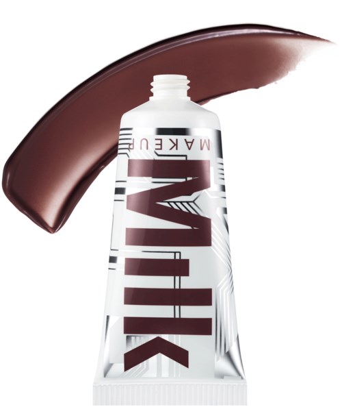 A white tube of makeup with bold, brown text, and a brown smear of product above it.