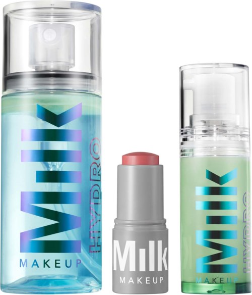 Twee make-upflessen, een met blauwe vloeistof en een met groene, en een kleine grijze stick met 'Milk' erop.
