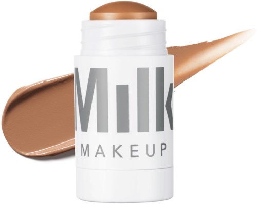 Meikkituote nimeltä "Milk" valkoisessa astiassa, jossa on beige huultenkiilto tai meikkivoide, joka valuu ulos.