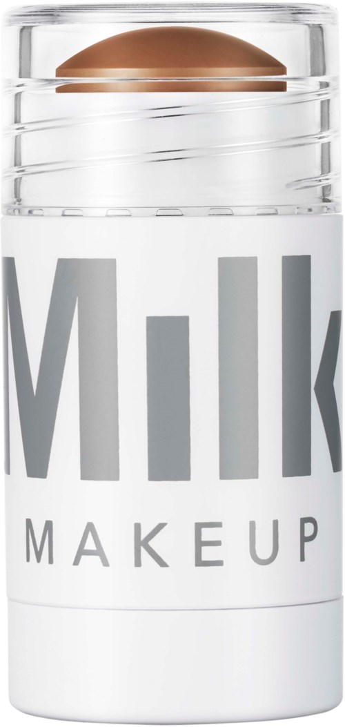 Et hudplejeprodukt i en klar beholder, mærket "Milk Makeup," med en brun pille inde i.