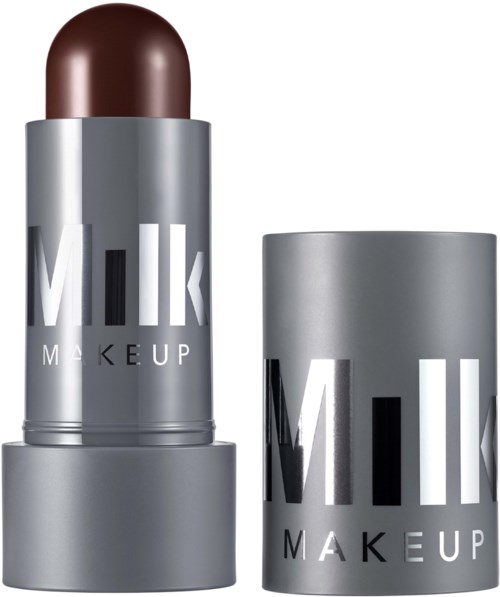 Silverfärgad behållare med en brun läppstiftskula, märkt Milk Makeup, stående upprätt bredvid en matchande kapsel.
