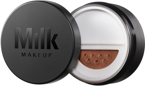 A makeup product in a black round container labeled "Milk" with a half-open lid showing a sponge applicator inside.