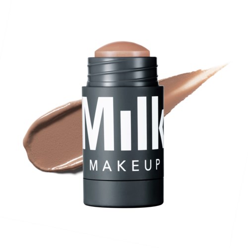 En beholder merket 'Milk Makeup' med beigefarget produkt, viser en smør på hvit bakgrunn.