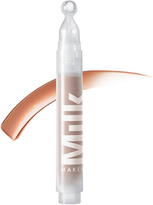 A white pencil-shaped container with a clear cap, featuring the word 'MILK' and a swatch of creamy makeup.