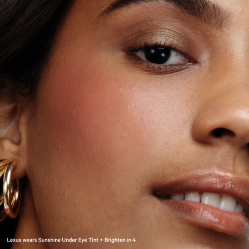 Close-up of a woman's face showing smooth skin, eye makeup, and a gentle smile.