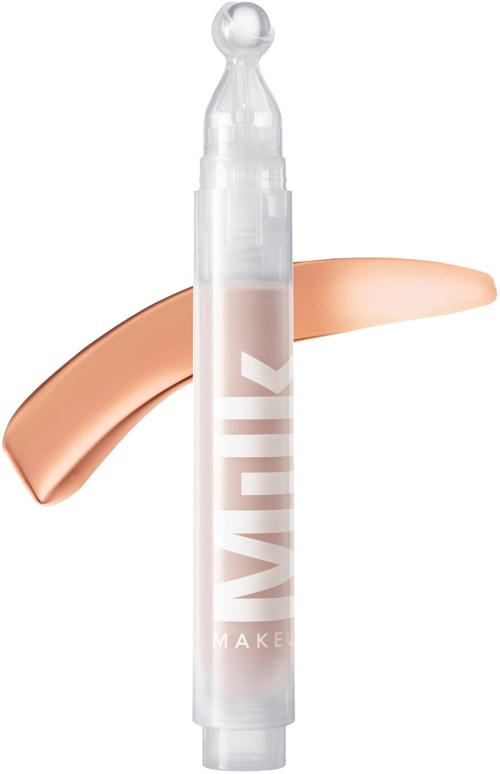 A white tube with a clear tip, labeled "MAKEUP" in large letters. There is a beige, slightly curved makeup swatch behind it.