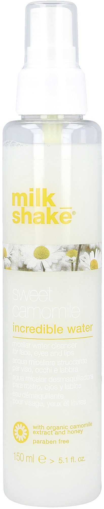 En lång, vit sprayflaska märkt "milk shake" med gul text och en daisydesign.