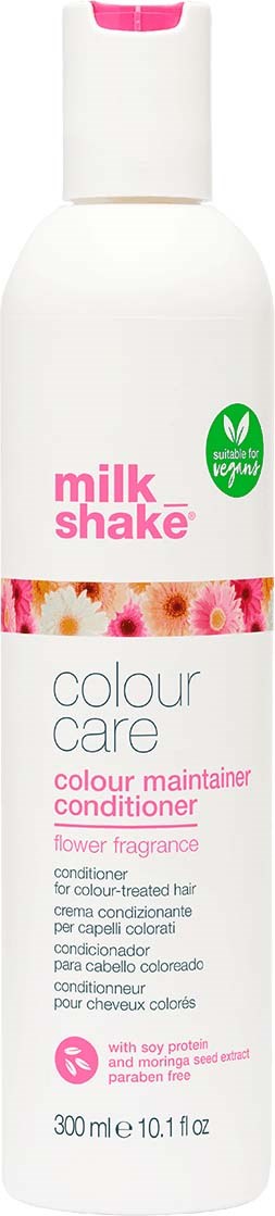 Eine weiße Flasche mit Milkshake-Farbpflegespüler, mit Blumen-Duft, geeignet für coloriertes Haar, und als vegan gekennzeichnet.