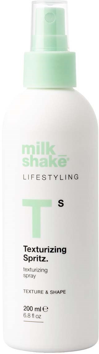 Biała butelka z zielonym nakrętkiem, oznaczona jako Milk Shake Lifestyle Texturizing Spray do tekstury i kształtu.