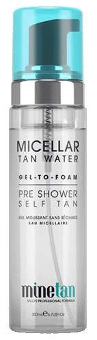 En klar genomskinlig flaska med blå lock, märkt 'Micellar TAN WATER' för förbad självtanning.