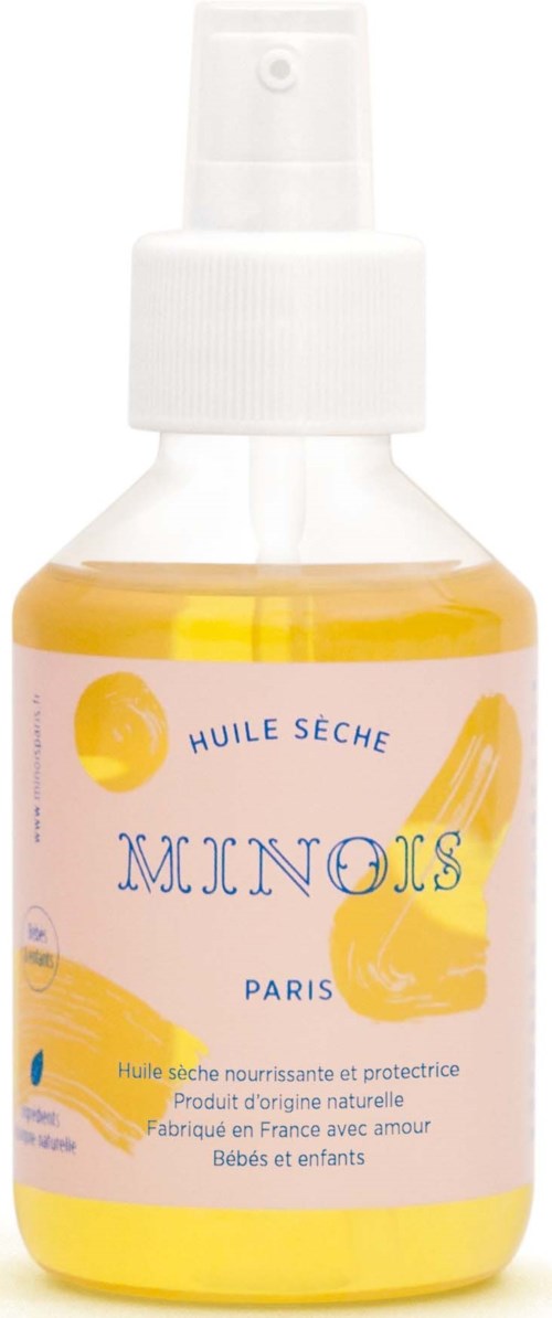 En liten sprayflaska med gul vätska, märkt 'Huile Seche Minois Paris', för bebis- och barnvård.