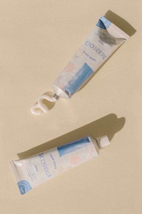 Two tubes of cream or gel with white caps, one partly squeezed out, casting shadows on a light background.