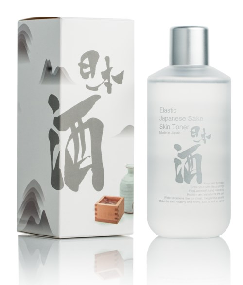 Butelka kosmetyków i pudełko z japońskimi znakami, oznaczone 'Elastic Japanese Sake Skin Toner', oraz mały drewniany przedmiot.