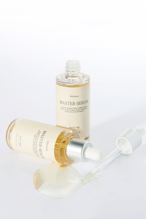 En hudpleieflesk med pipette, merket 'Master Serum,' ligger på en hvit overflate.