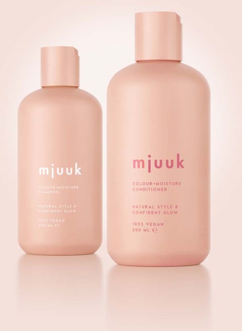To rosa flasker merket 'miuuk' med myke farger, en liten og en stor, står mot en lys rosa bakgrunn.