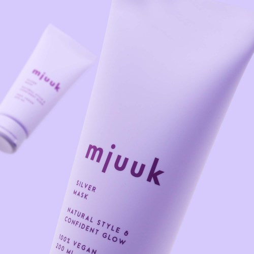En stor hvit tube merket 'mjuuk' med lilla tekst, for ansiktsmaske.