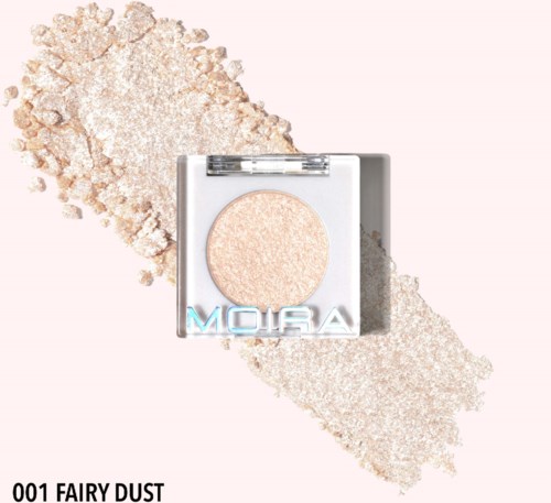 En trykt pudder makeup med navnet 'Fairy Dust' på emballagen, omgivet af løs pudder. Lys glitrende farve.