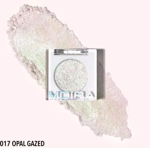 En lille kvadratisk øjenskyggepalette med en skinnende øjenskygge kaldet 'OPAL GAZED' og 'MOIRA' logo, på en glitrende baggrund.