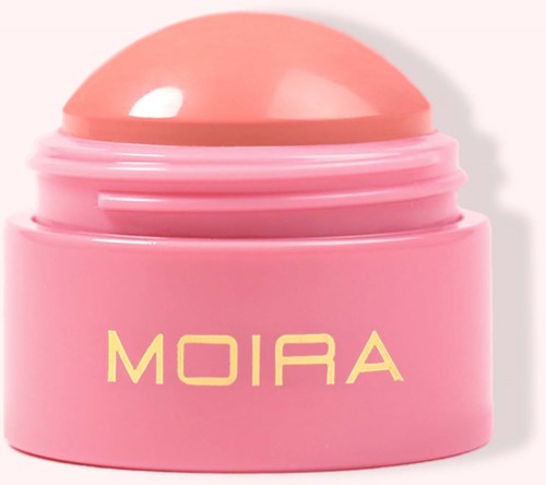 Eine runde, rosafarbene Verpackung mit passendem Deckel, beschriftet 'MOIRA'. Es sieht aus wie ein Kosmetik- oder Hautpflegeprodukt.