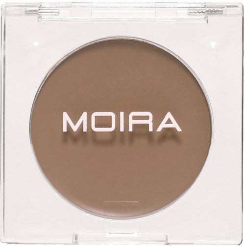 Ett runt, beige sminkprodukt i tydligt plastförpackning med ordet 'MOIRA' på.
