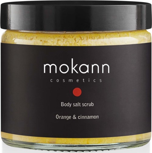 En krukke med Mokann Cosmetics kroppssalt skrubb med duft av appelsin og kanel. Svart lokk og etikett. Gult salt er synlig inni.