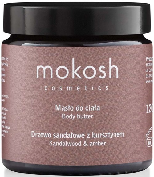 En burk kroppssmörj med märket 'mokosh cosmetics' och doft av sandelträ och bärnsten. Den är svart med en rosa etikett.