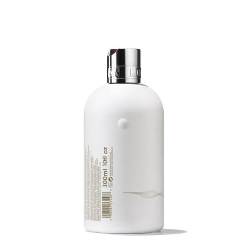 A white bottle with a silver cap, labeled with product details and a barcode, stands upright.