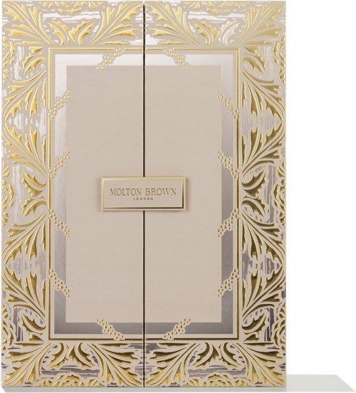 Elegant gyllene och vita dekorativa dörrar med en skylt som säger "Molton Brown London" i mitten.