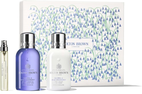 Sett med hudpleieflasker og spray med en dekorativ eske bak, som har blå og grønne blomster mønster.