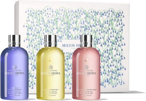 Drie pastelgekleurde flessen van Molton Brown, met een decoratieve achtergrond en een witte doos erachter.