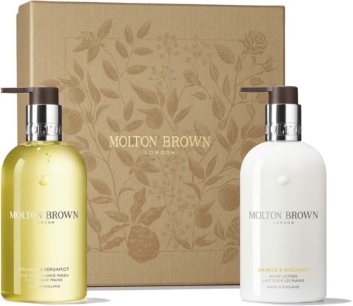 Two bottles of hand wash and hand lotion with a beige box and floral design behind them.