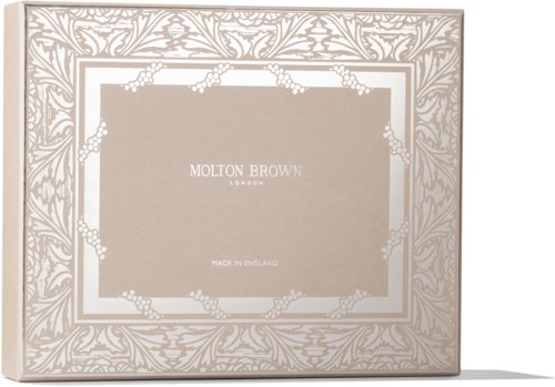 En beige eske med intrikate hvite blomsterdesign og teksten 'Molton Brown London' i midten.