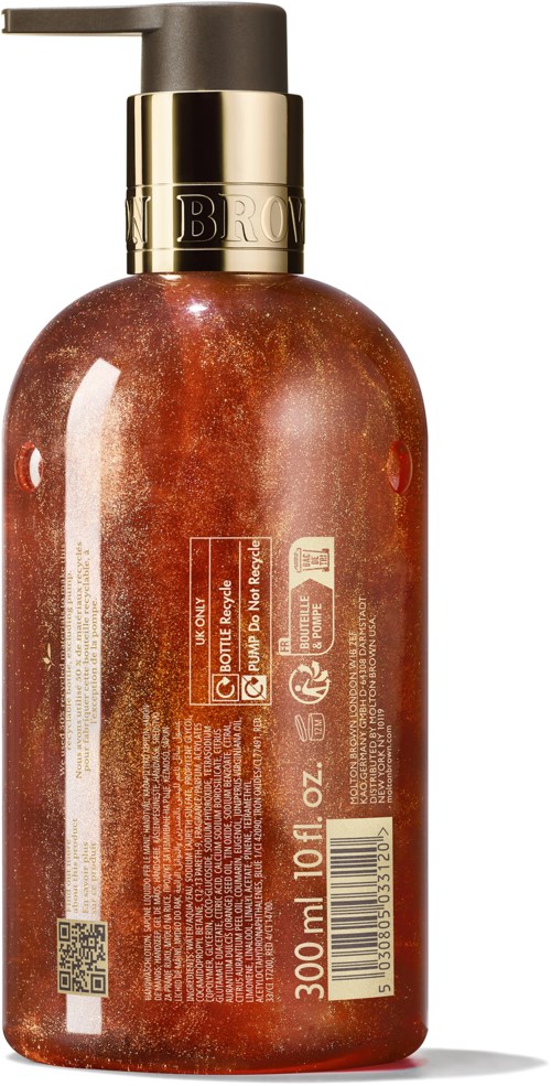 En brunoransje flaske med kroppsolje eller dusjgelflask med svart og gull pumpe, 300 ml kapasitet, og tekst og symboler på etiketten.