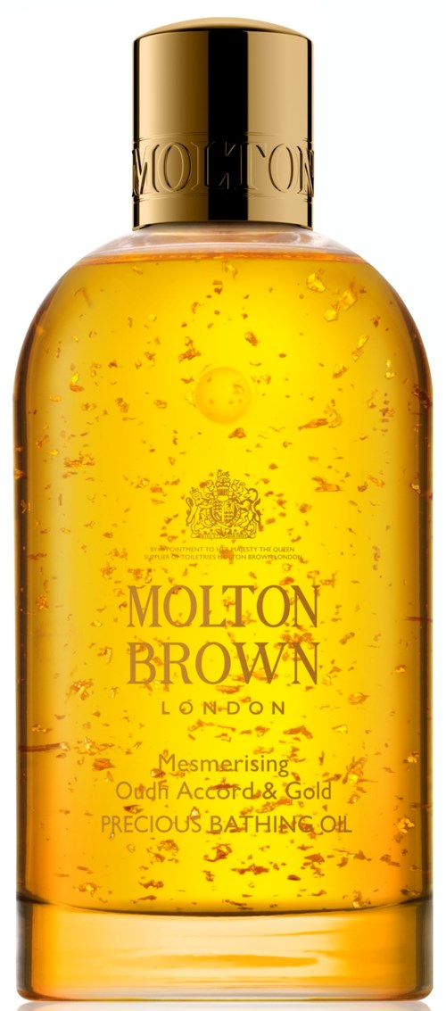 En gul-orange flaska med guldlock innehållande en vätska med små bubblor, märkt Molton Brown London.
